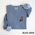 Blue Jean crewneck sweatshirt laid flat with a rolled cuff, embroidered with a small sitting golden retriever on the left chest