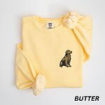 Butter crewneck sweatshirt laid flat, embroidered with a small sitting golden retriever on the left chest