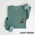 Light Green crewneck sweatshirt laid flat with a rolled cuff, embroidered with a small sitting golden retriever on the left chest