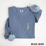 Blue Jean crewneck sweatshirt laid flat, embroidered with a small light grey goldendoodle sitting on the left chest