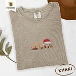 Khaki Comfort Colors T-shirt embroidered with a golden retriever puppy napping with its head on its paws in a red Santa hat