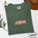 Moss Comfort Colors T-shirt embroidered with a golden retriever puppy napping with its head on its paws in a red Santa hat