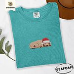 Seafoam Comfort Colors T-shirt embroidered with a golden retriever puppy napping with its head on its paws in a red Santa hat