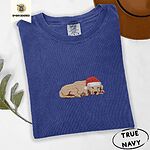 True Navy Comfort Colors T-shirt embroidered with a golden retriever puppy napping with its head on its paws in a red Santa hat