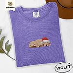 Violet Comfort Colors T-shirt embroidered with a golden retriever puppy napping with its head on its paws in a red Santa hat