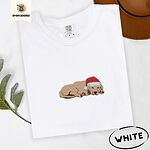 White Comfort Colors T-shirt embroidered with a golden retriever puppy napping with its head on its paws in a red Santa hat