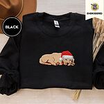 Black crewneck sweatshirt with a brown felt hat and dried bunny tail grass, embroidered with a golden retriever puppy asleep in a red Santa hat, its head resting on its front paws