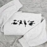Spooky black cat sweatshirt in light heather grey with four embroidered black cats, a crow, bats and a tiny ghost across the chest