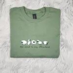 Green T-shirt with five embroidered sheep and the Lord is my Shepherd in black script