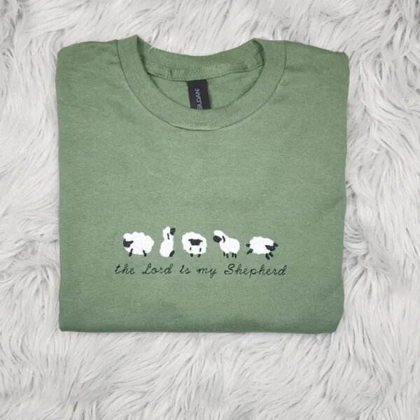 Green T-shirt with five embroidered sheep and the Lord is my Shepherd in black script