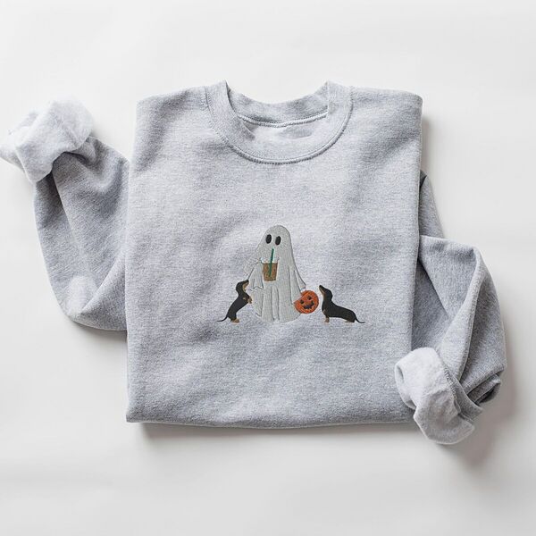 Sport Grey crewneck sweatshirt laid flat on white, embroidered with a ghost sipping iced coffee between two black and tan dachshunds and a jack-o'-lantern pail