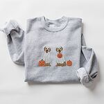 Sport Grey crewneck sweatshirt laid flat with a rolled sleeve, embroidered with two golden retrievers in white ghost sheets with a jack-o'-lantern, a pumpkin bucket and a small pumpkin