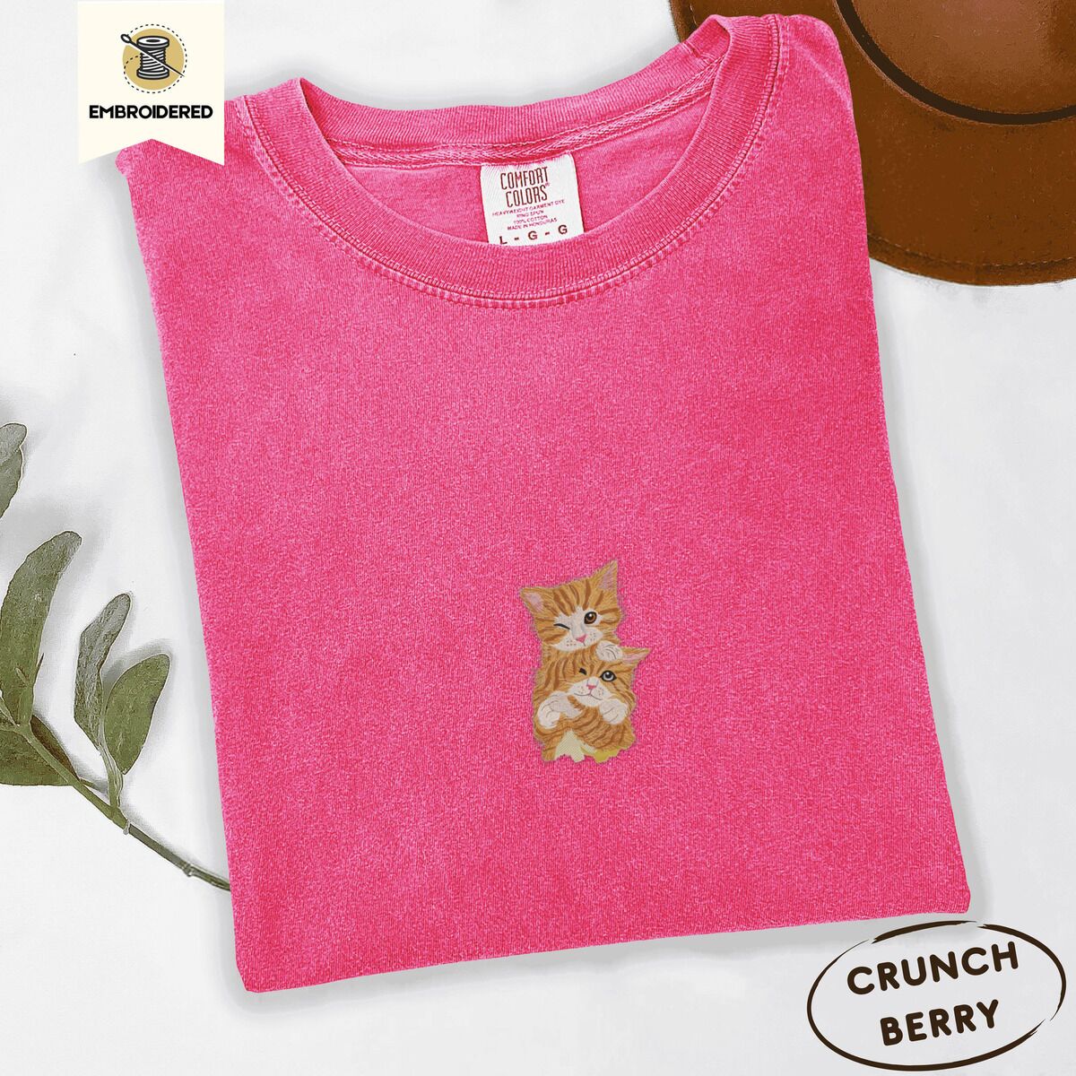Two Kittens Shirt – Crunchberry Crunchberry Comfort Colors T-shirt embroidered with two orange tabby kittens, one winking with a paw on the other's head