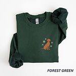 Forest Green crewneck sweatshirt laid flat on a white background, embroidered with a small golden rust vizsla sitting among white snowflakes on the left chest
