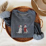 Dark Heather crewneck sweatshirt folded in a wicker basket, embroidered with two white labs in Santa hats, one holding a candy cane and one in a long red scarf