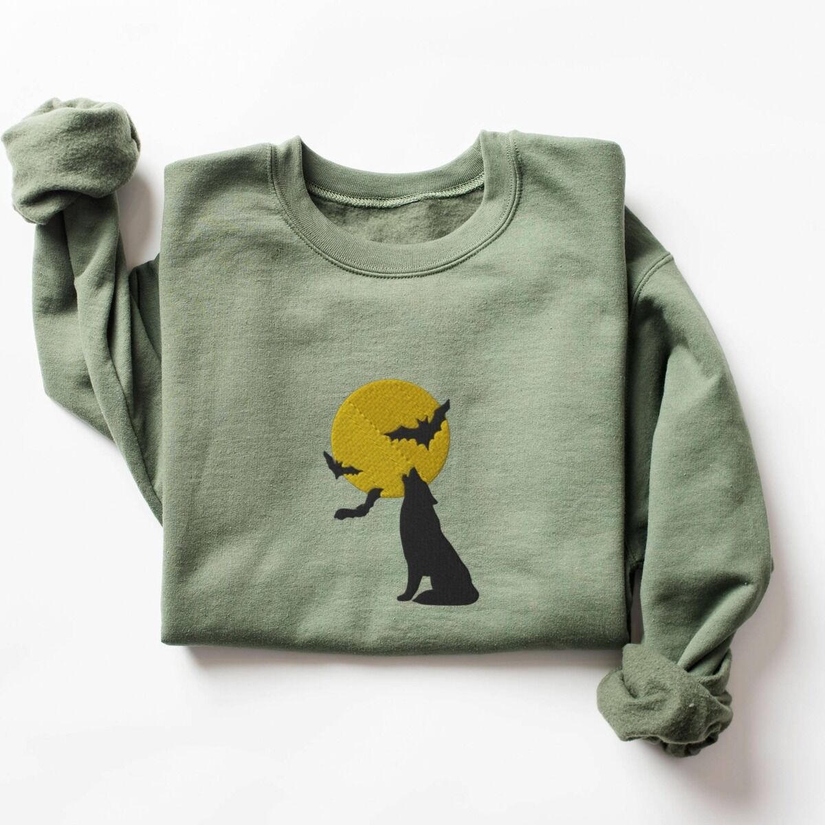 Wolf Howling at the Moon Sweatshirt – Military Green Military Green crewneck sweatshirt laid flat on a white background, embroidered with a black wolf silhouette howling at a yellow full moon with three bats