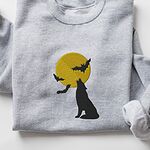 Sport Grey crewneck sweatshirt laid flat, embroidered with a black wolf silhouette howling at a yellow full moon with three bats