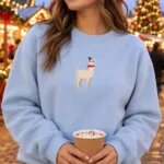 Woman in a light blue llama Christmas sweatshirt at an outdoor Christmas market with string lights