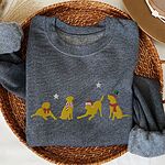 Dark Heather crewneck sweatshirt folded in a wicker basket, embroidered with four playful yellow labs in a Santa hat, an elf hat, a red bow and a striped scarf under silver stars