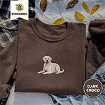Dark Chocolate crewneck sweatshirt on a plaid flannel shirt with yellow autumn leaves and denim shorts, embroidered with a smiling yellow Labrador lying down with its front paws stretched out