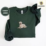 Forest Green crewneck sweatshirt folded on a white background, embroidered with a smiling yellow Labrador lying down with its front paws stretched out