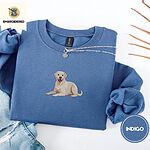 Indigo Blue crewneck sweatshirt folded with light jeans and dried twigs, embroidered with a smiling yellow Labrador lying down with its front paws stretched out