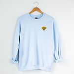 Light Blue crewneck sweatshirt on a hanger, embroidered with a small smiling yellow Labrador face with floppy ears and a pink tongue on the left chest