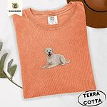 Terracotta Comfort Colors T-shirt embroidered with a smiling yellow Labrador lying down with its front paws stretched out