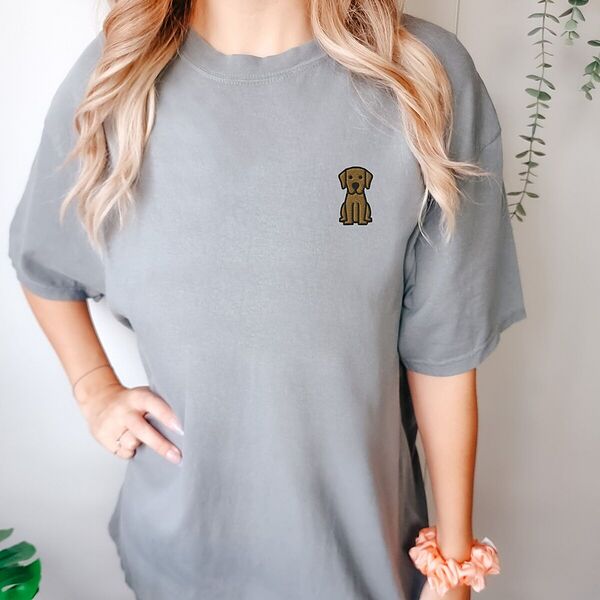 Woman in a Grey T-shirt embroidered with a small golden cartoon Labrador puppy sitting with floppy ears on the left chest