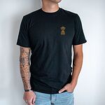 Man in a Black T-shirt embroidered with a small golden cartoon Labrador puppy sitting with floppy ears on the left chest