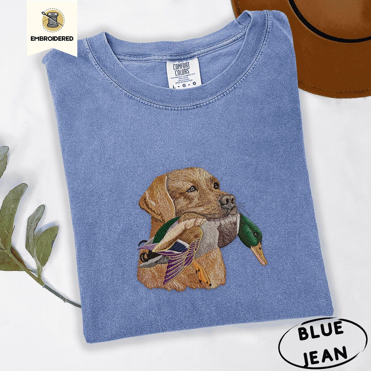 Yellow Lab Shirt – Blue Jean Blue Jean Comfort Colors T-shirt embroidered with a yellow Labrador head carrying a mallard drake in its mouth