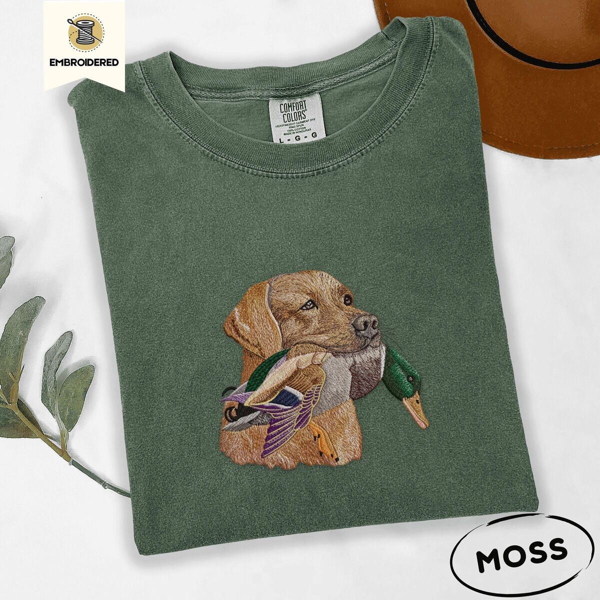 Yellow Lab Shirt – Moss Moss Comfort Colors T-shirt embroidered with a yellow Labrador head carrying a mallard drake in its mouth