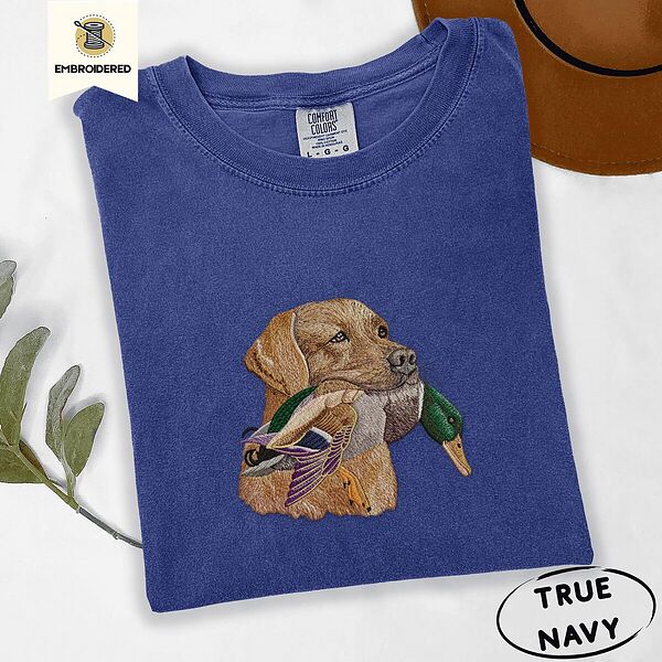 True Navy Comfort Colors T-shirt embroidered with a yellow Labrador head carrying a mallard drake in its mouth