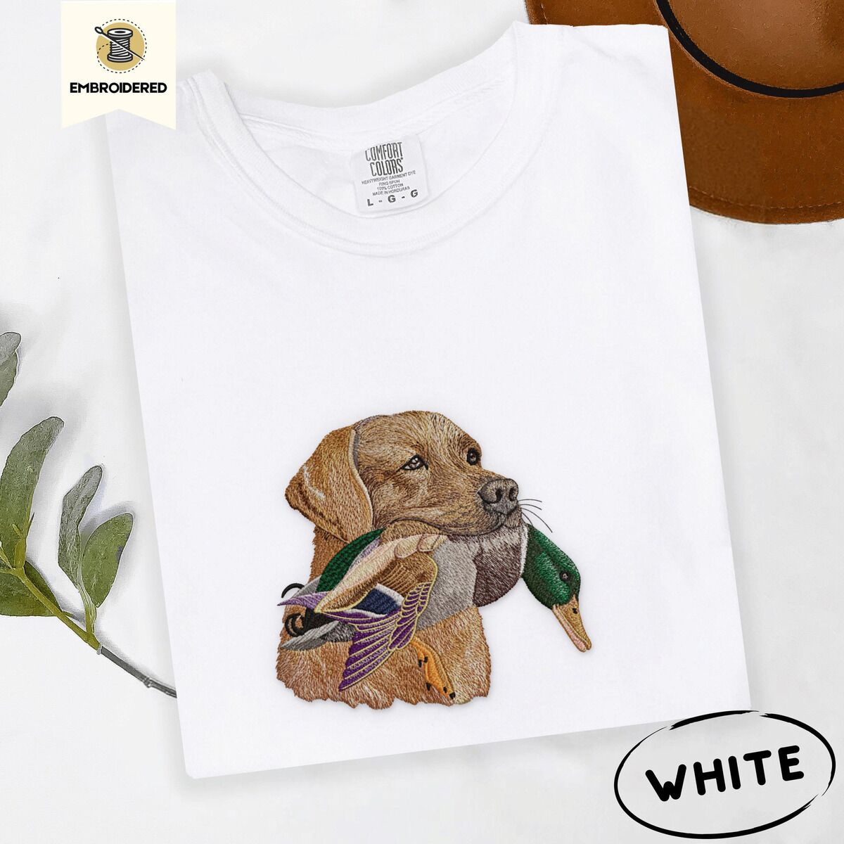 Yellow Lab Shirt – White White Comfort Colors T-shirt embroidered with a yellow Labrador head carrying a mallard drake in its mouth