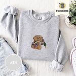 Ash crewneck sweatshirt folded with denim shorts, white sneakers and a potted plant, embroidered with a yellow Labrador head carrying a mallard drake in its mouth