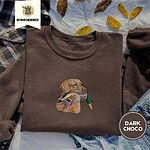 Dark Chocolate crewneck sweatshirt on a plaid flannel shirt with yellow autumn leaves and denim shorts, embroidered with a yellow Labrador head carrying a mallard drake in its mouth